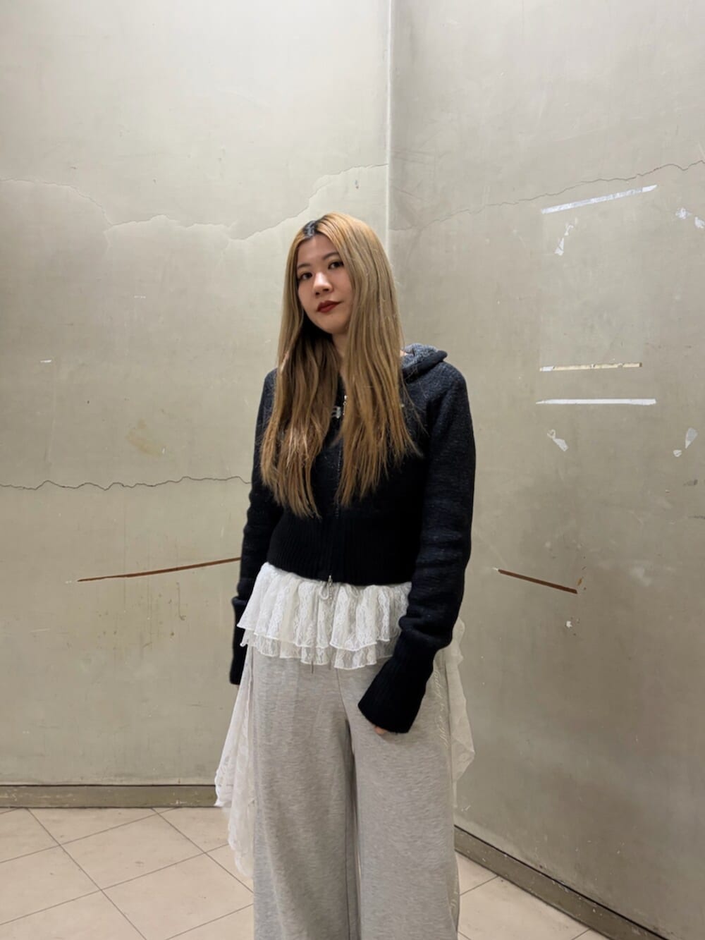 ブラック系のパーカー、グレー系のスウェットパンツ、ブラック系のローファーを着用したレディースの冬コーディネートの6枚目の写真