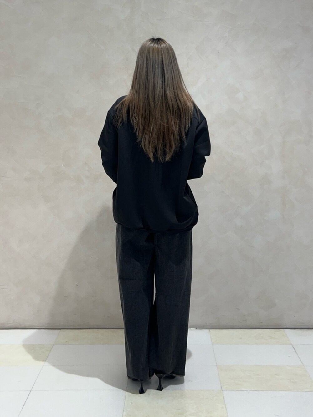 ブラック系のパンプス、ブラック系のデニムパンツ、ブラック系のアンサンブルを着用したレディースの秋コーディネートの3枚目の写真