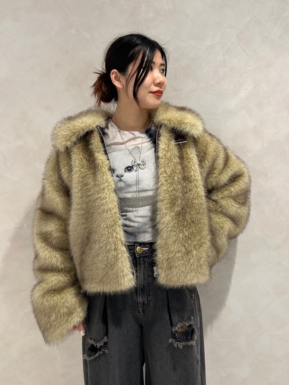 ブラック系のデニムパンツ、ゴールド系のパンプス、ブラック系のTシャツ/カットソーを着用したレディースの秋コーディネートの6枚目の写真