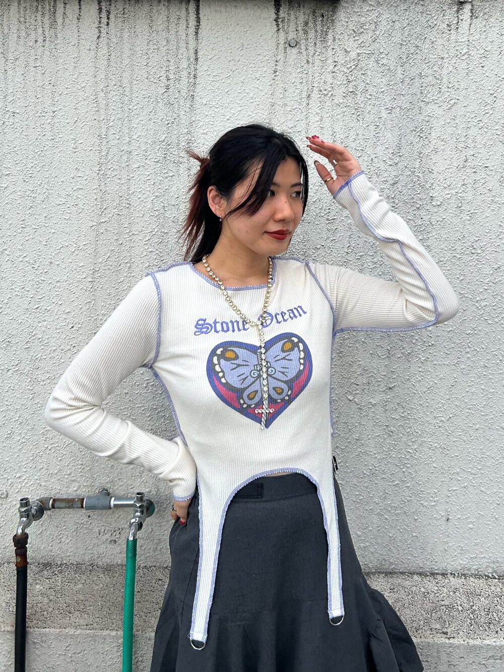 ブラック系のブーツ、ホワイト系のTシャツ/カットソー、グレー系のスカートを着用したレディースの秋コーディネートの4枚目の写真