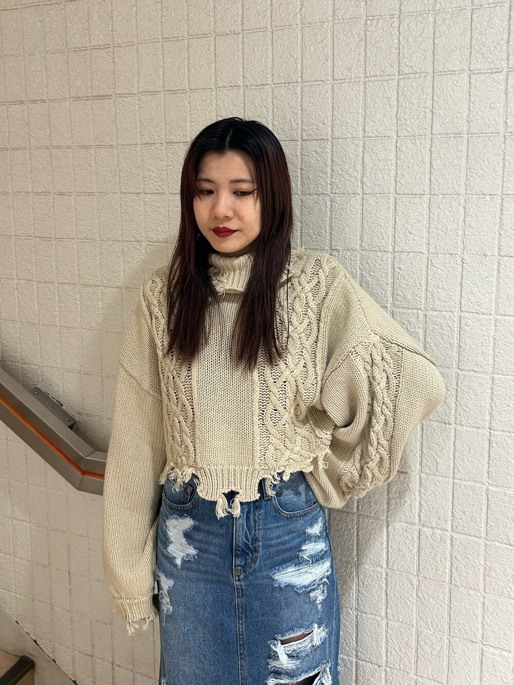 ブラック系のブーツ、ブルー系のデニムスカート、ホワイト系のニット/セーターを着用したレディースの冬コーディネートの4枚目の写真