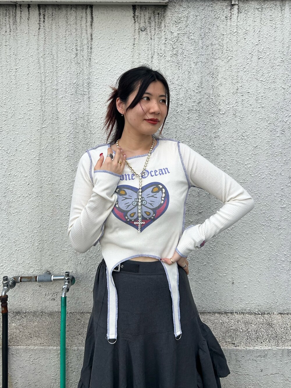 ブラック系のブーツ、ホワイト系のTシャツ/カットソー、グレー系のスカートを着用したレディースの秋コーディネートの5枚目の写真