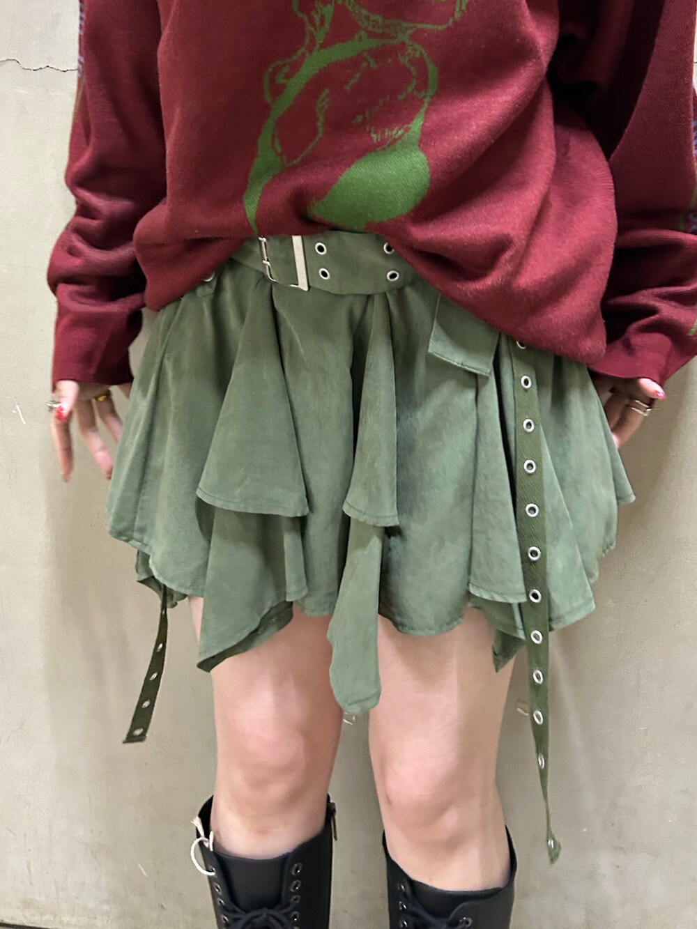 ブラック系のブーツ、レッド系のニット/セーター、グリーン系のスカートを着用したレディースの秋コーディネートの9枚目の写真