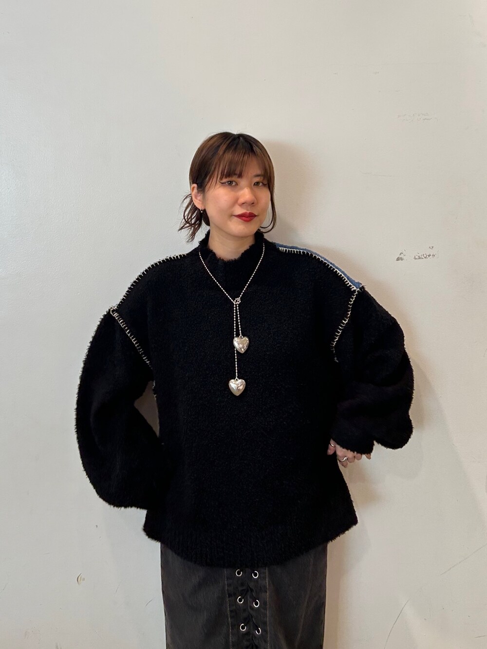 ブラック系のデニムパンツ、ブラック系のブーツ、ブラック系のニット/セーターを着用したレディースの秋コーディネートの3枚目の写真