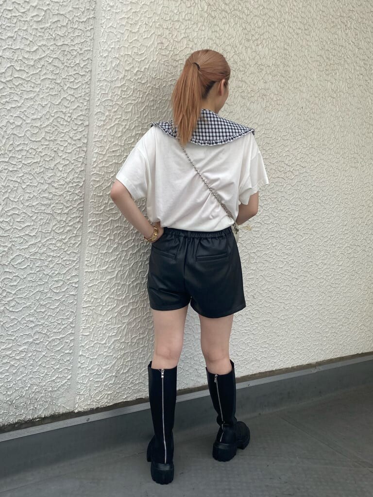 ブラック系のブーツ、ホワイト系のTシャツ/カットソー、ホワイト系のボストンバッグを着用したレディースの夏コーディネートの4枚目の写真