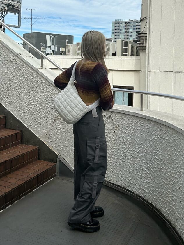 ブラック系のその他シューズ、グレー系のカーゴパンツ、イエロー系のカーディガン/ボレロを着用したレディースの秋コーディネートの3枚目の写真