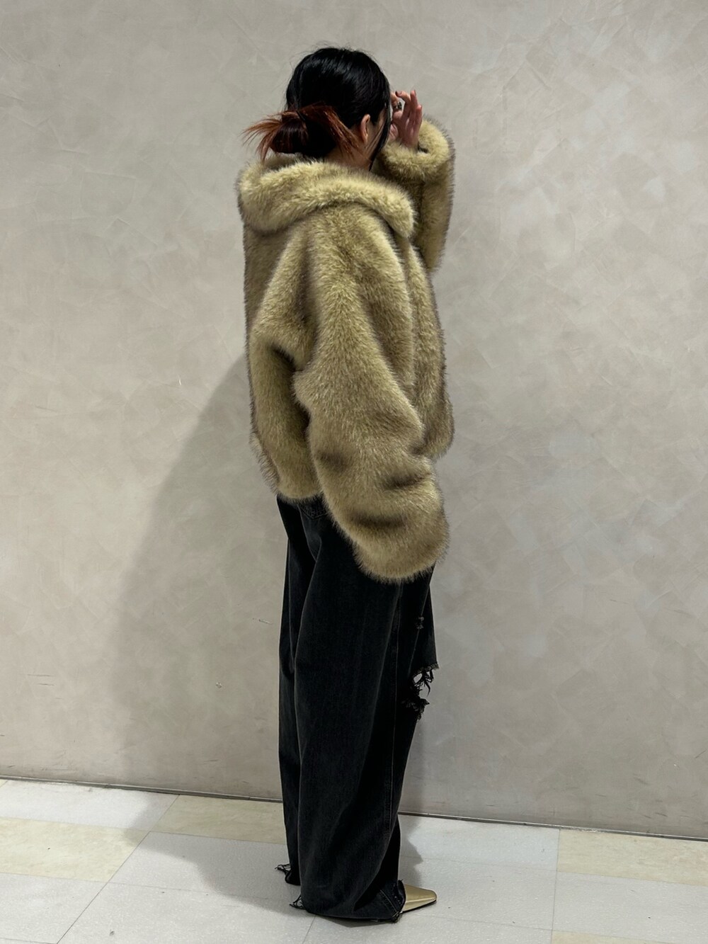 ブラック系のデニムパンツ、ゴールド系のパンプス、ブラック系のTシャツ/カットソーを着用したレディースの秋コーディネートの3枚目の写真