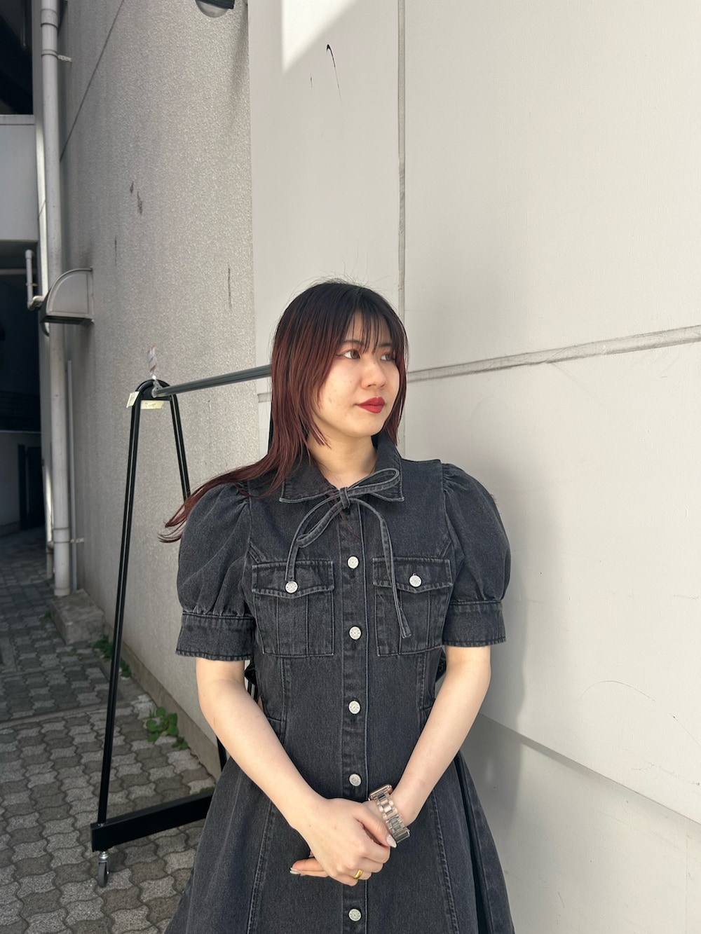 ブラック系のワンピース、ブラック系のブーツを着用したレディースの春コーディネートの3枚目の写真