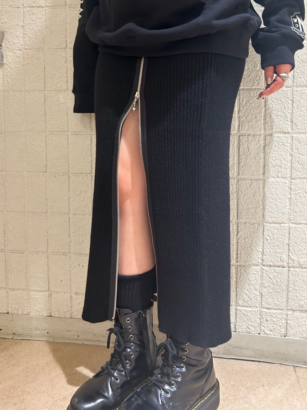 ブラック系のブーツ、ブラック系のスカート、ブラック系のパーカーを着用したレディースの秋コーディネートの10枚目の写真