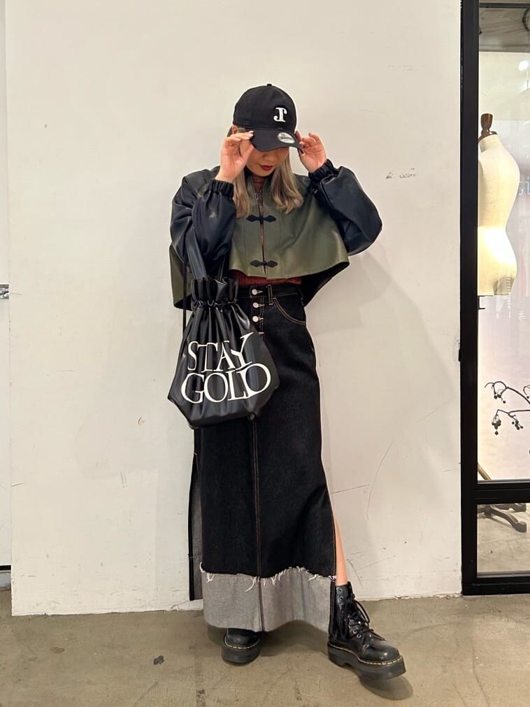 ブラック系のデニムスカート、ブラック系のその他シューズ、ブラック系のバックパック/リュックを着用したレディースの秋コーディネートの2枚目の写真