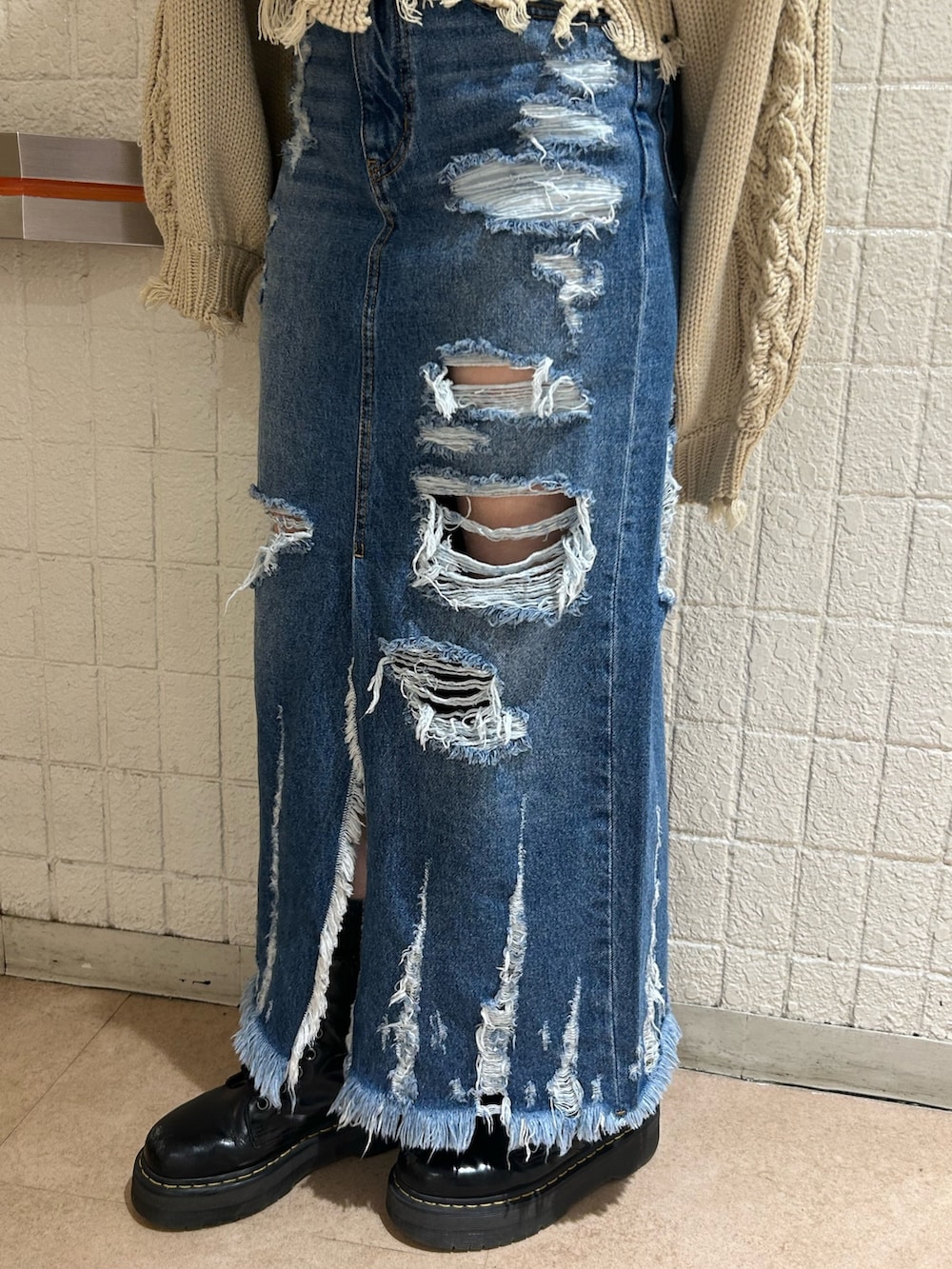 ブラック系のブーツ、ブルー系のデニムスカート、ホワイト系のニット/セーターを着用したレディースの冬コーディネートの8枚目の写真