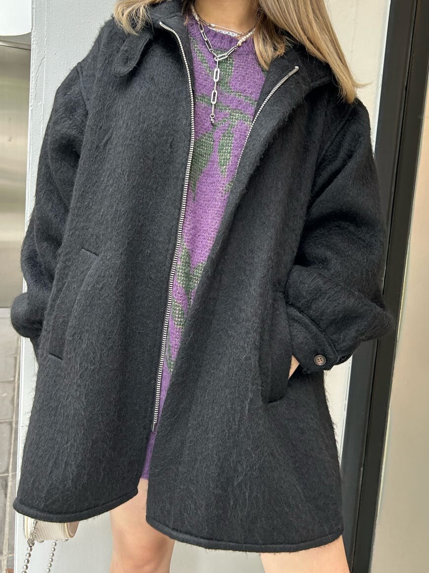 ブラック系のブーツ、ホワイト系のハンドバッグ、ブラック系のデニムパンツを着用したレディースの秋コーディネートの7枚目の写真