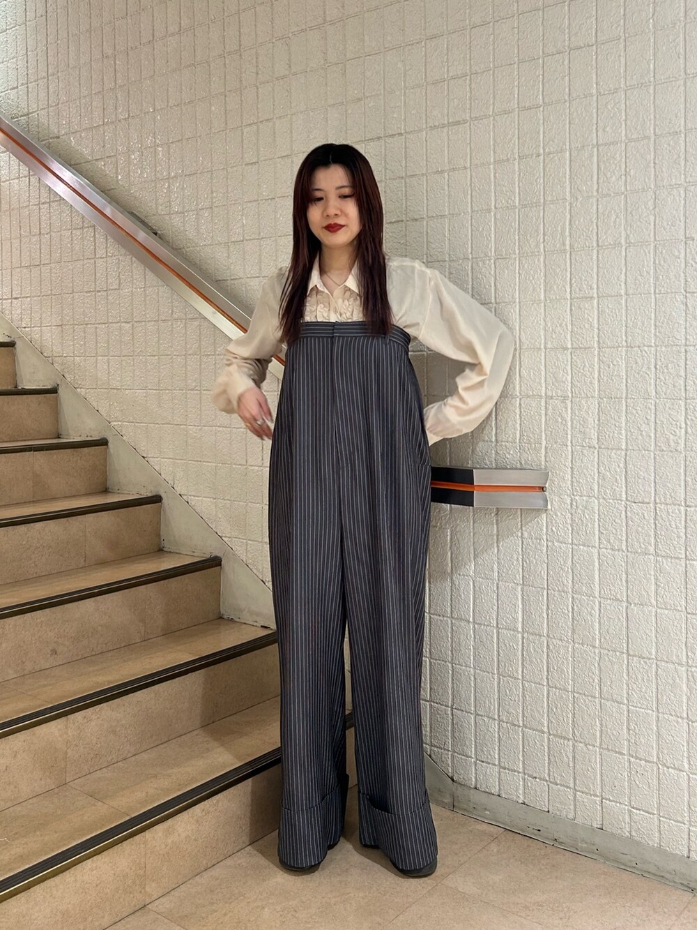 ブラック系のブーツ、ホワイト系のシャツ/ブラウス、グレー系のつなぎ/オールインワンを着用したレディースの冬コーディネートの2枚目の写真