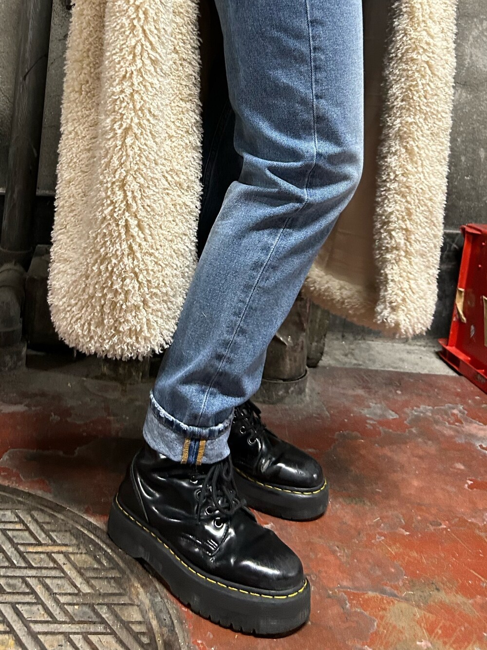 レッド系のニット/セーター、ブルー系のデニムパンツ、ホワイト系のその他アウターを着用したレディースの冬コーディネートの7枚目の写真