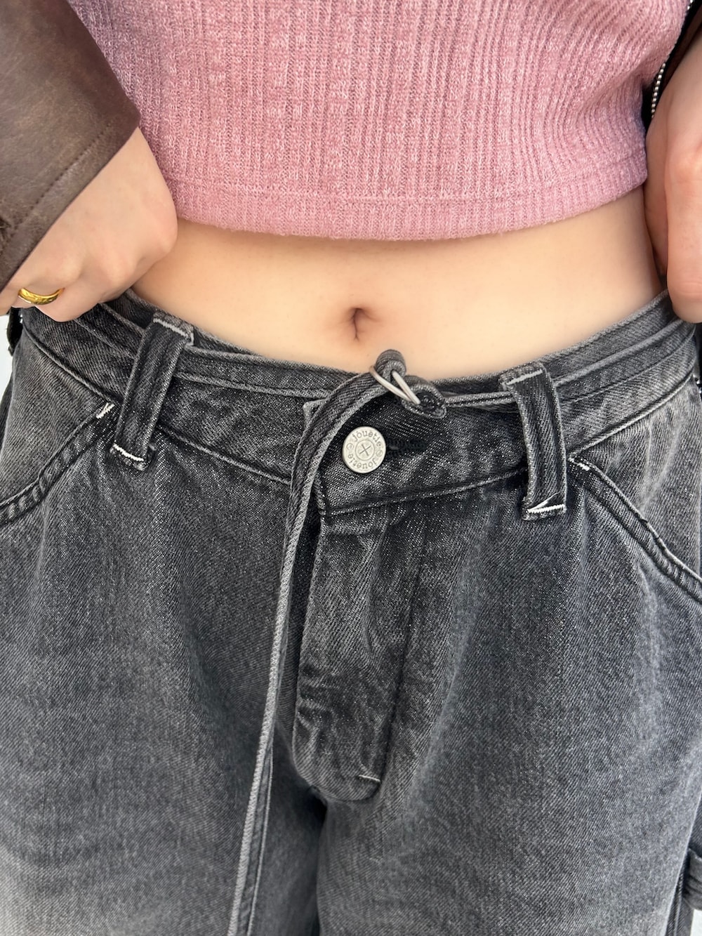 ブラック系のデニムパンツ、ホワイト系のスニーカー、ピンク系のTシャツ/カットソーを着用したレディースの夏コーディネートの7枚目の写真