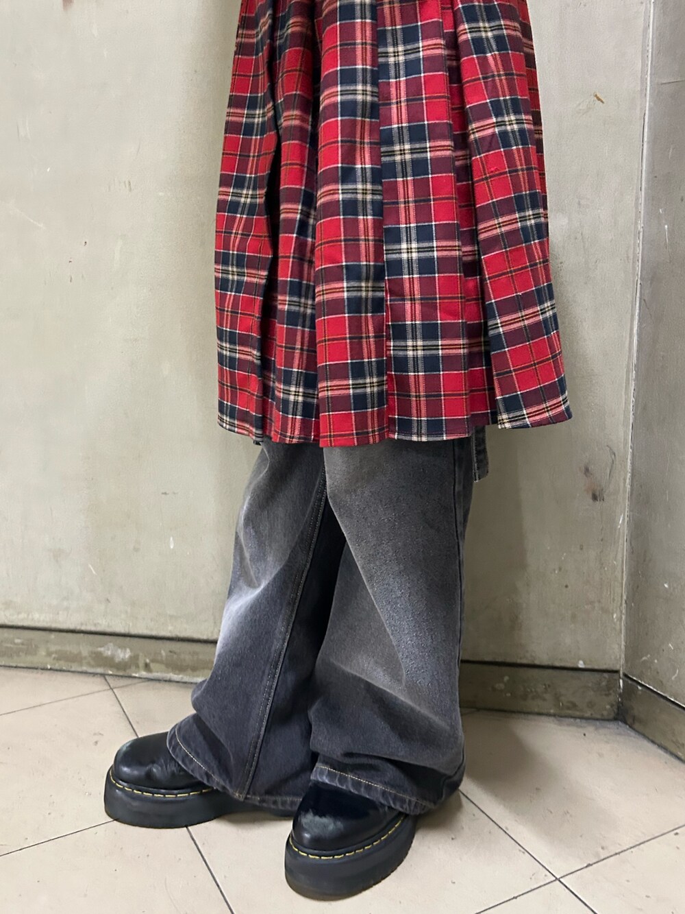 ブラック系のブーツ、ブラック系のTシャツ/カットソー、レッド系のスカートを着用したレディースの秋コーディネートの9枚目の写真