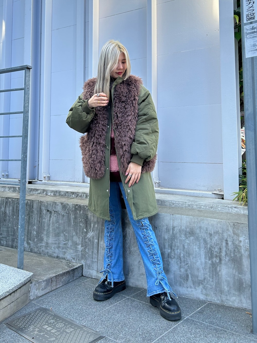 グリーン系のモッズコート、レッド系のニット/セーター、ホワイト系のTシャツ/カットソーを着用したレディースの秋コーディネートの2枚目の写真