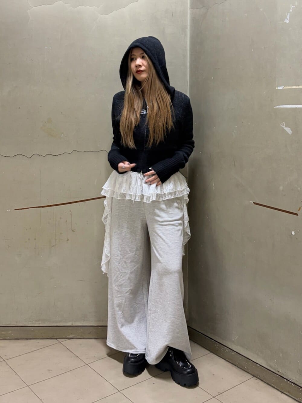 ブラック系のパーカー、グレー系のスウェットパンツ、ブラック系のローファーを着用したレディースの冬コーディネートの4枚目の写真