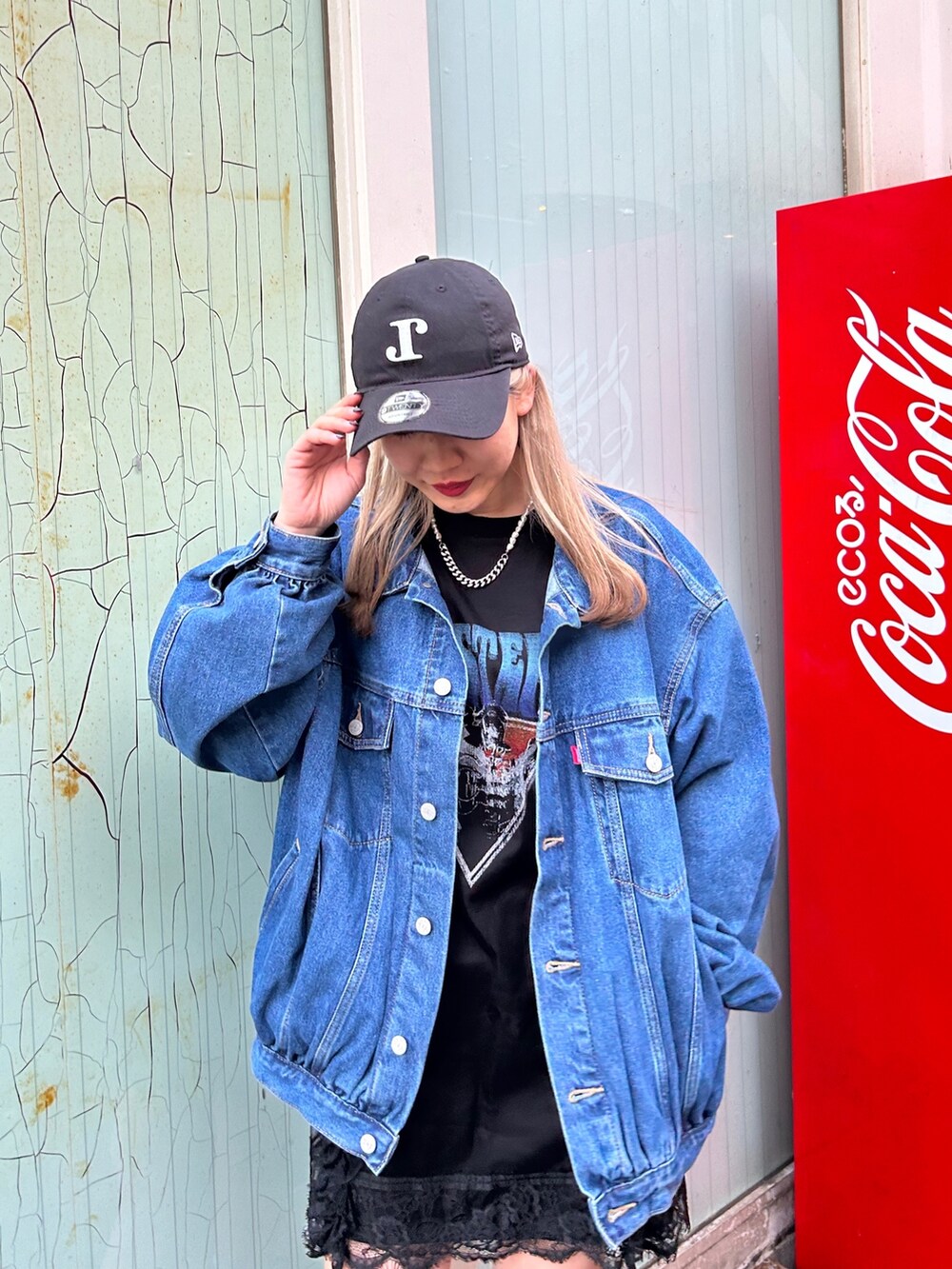 ブラック系のブーツ、ブラック系のワンピース、ブルー系のデニムジャケットを着用したレディースの春コーディネートの3枚目の写真