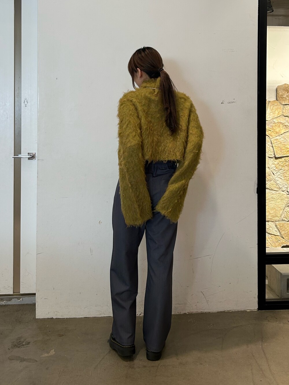 ブラック系のブーツ、イエロー系のニット/セーター、グレー系のその他パンツを着用したレディースの秋コーディネートの3枚目の写真