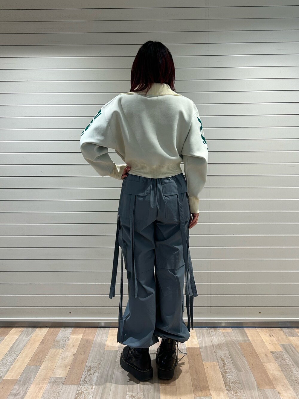 グレー系のその他パンツ、ブラック系のブーツ、ホワイト系のニット/セーターを着用したレディースの春コーディネートの2枚目の写真