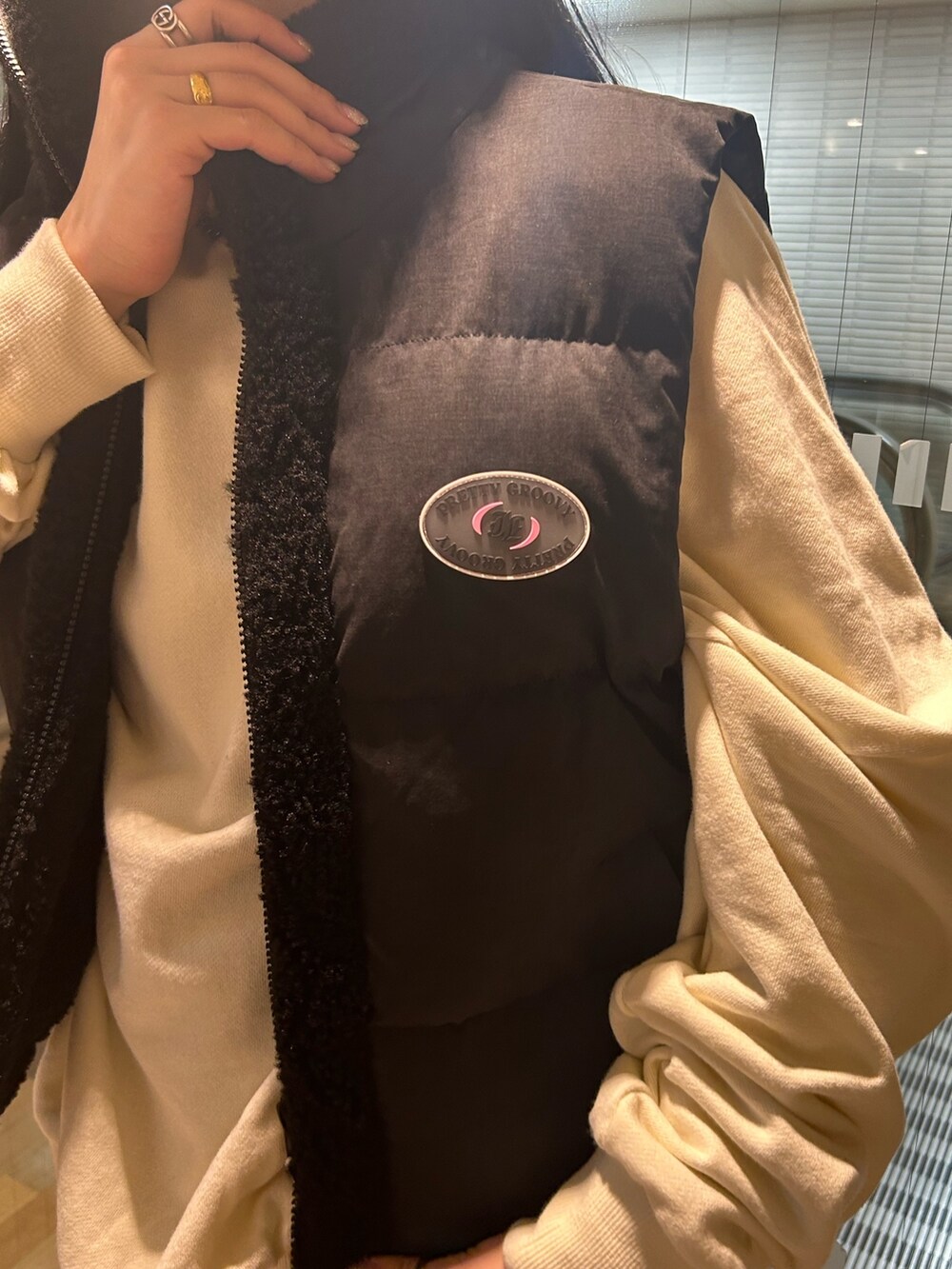 ブラック系のブーツ、ブラック系のダウンベスト、ホワイト系のTシャツ/カットソーを着用したレディースの秋コーディネートの6枚目の写真