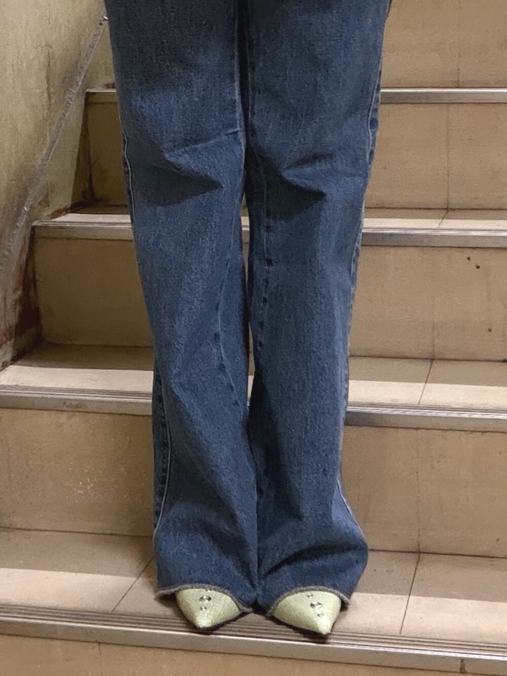 ベージュ系のワンピース、ホワイト系のTシャツ/カットソー、ブルー系のデニムパンツを着用したレディースの春コーディネートの6枚目の写真