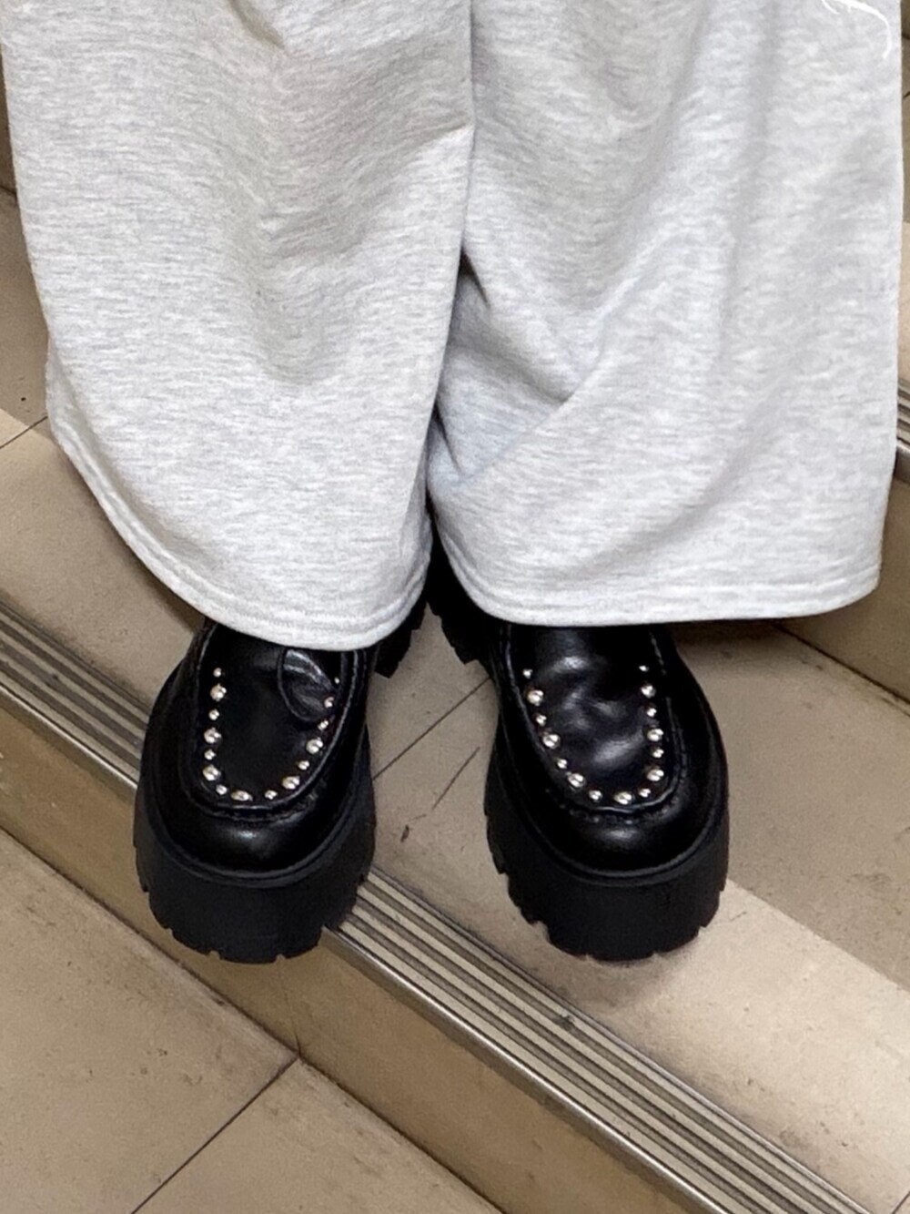 ブラック系のパーカー、グレー系のスウェットパンツ、ブラック系のローファーを着用したレディースの冬コーディネートの9枚目の写真