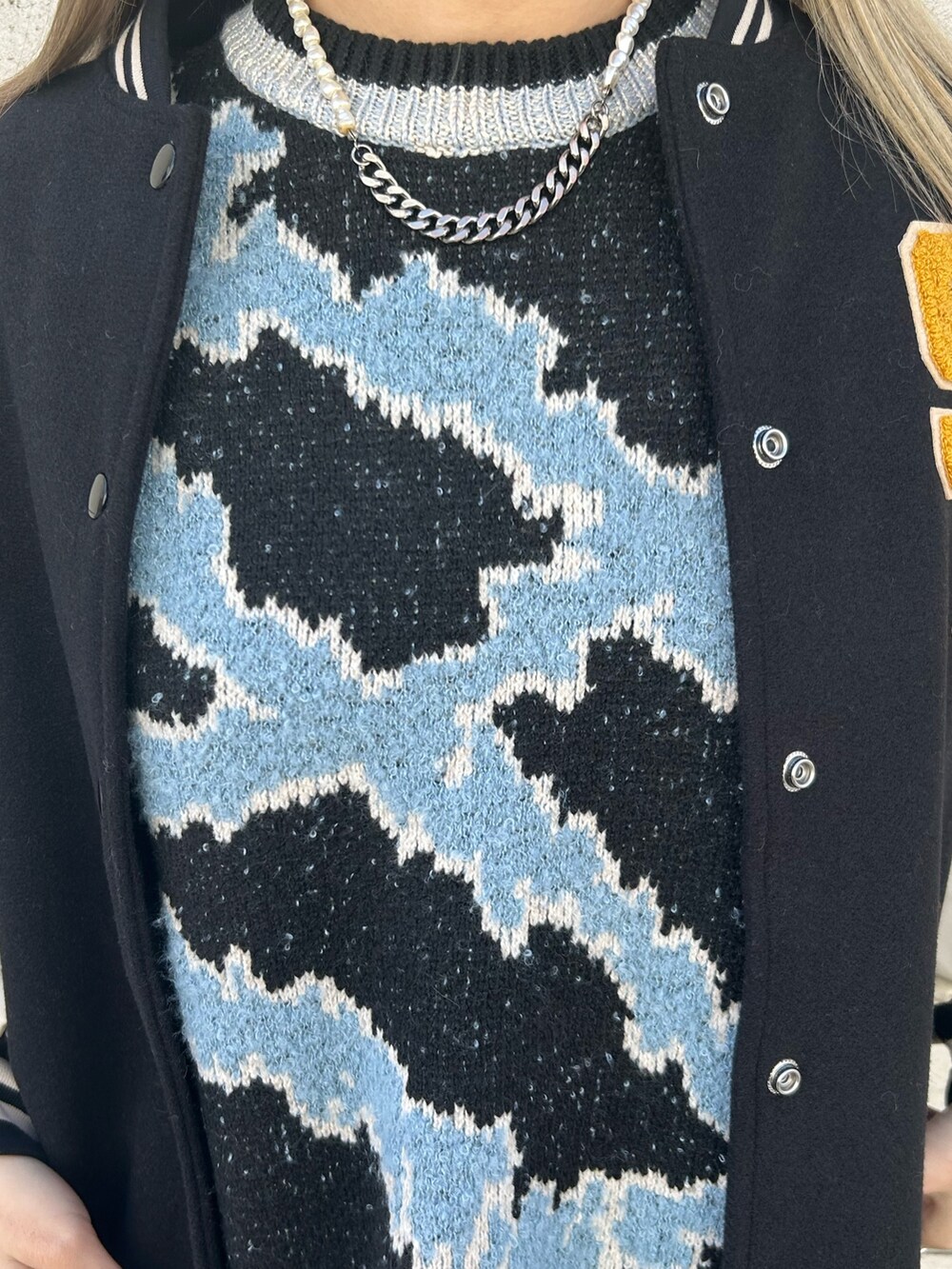 ブラック系のデニムパンツ、ホワイト系のブーツ、ブラック系のニット/セーターを着用したレディースの冬コーディネートの5枚目の写真