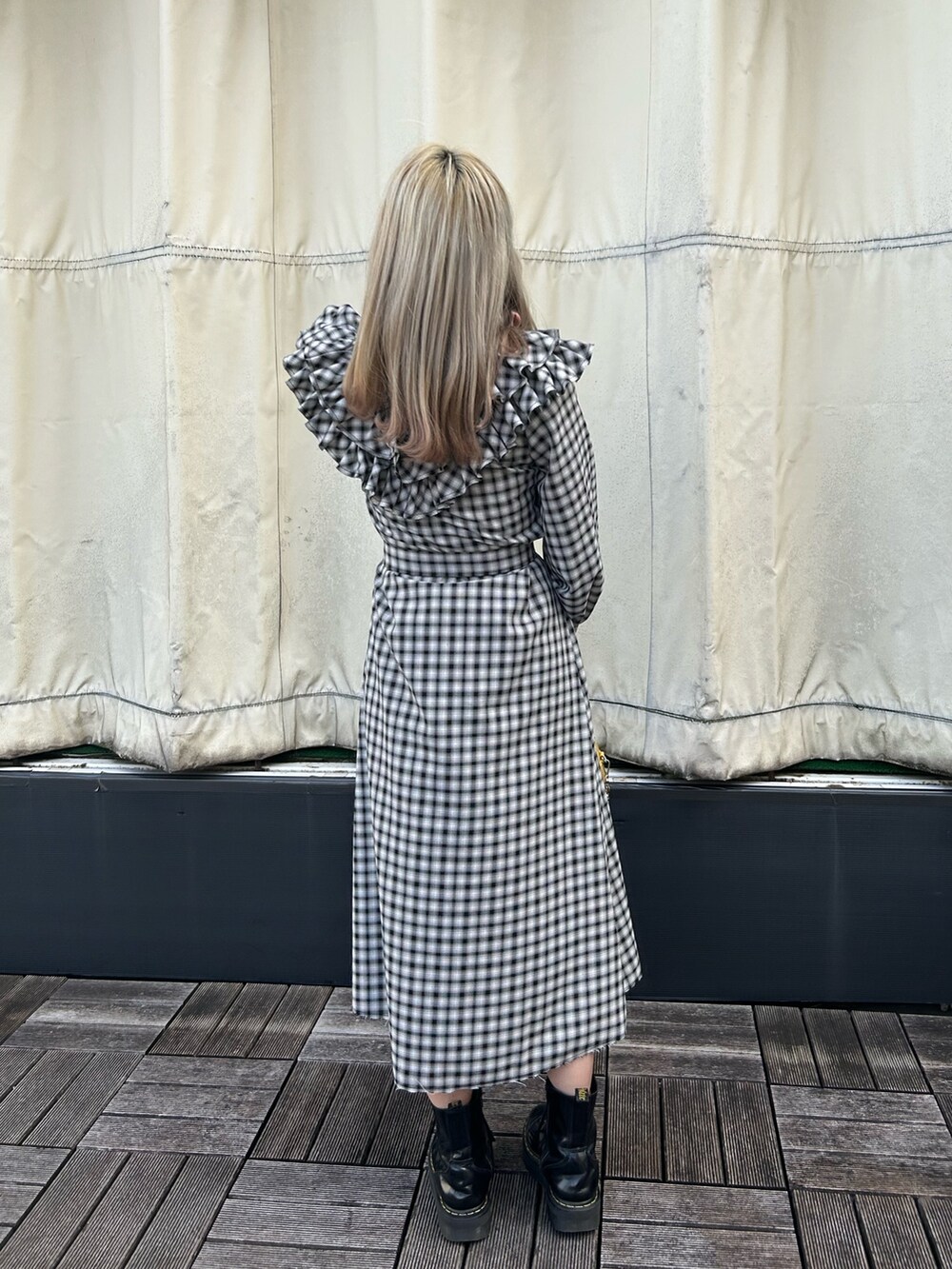 ブラック系のブーツ、イエロー系のショルダーバッグ、ブラック系のワンピースを着用したレディースの冬コーディネートの2枚目の写真