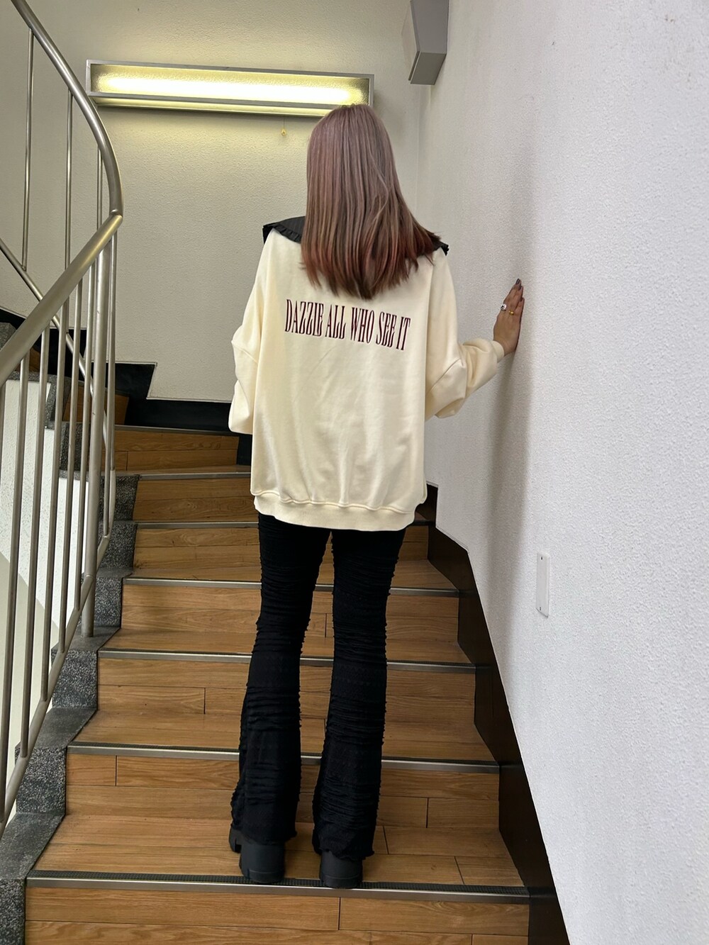 ホワイト系のスウェット、ブラック系のその他パンツ、ブラック系のローファーを着用したレディースの冬コーディネートの2枚目の写真