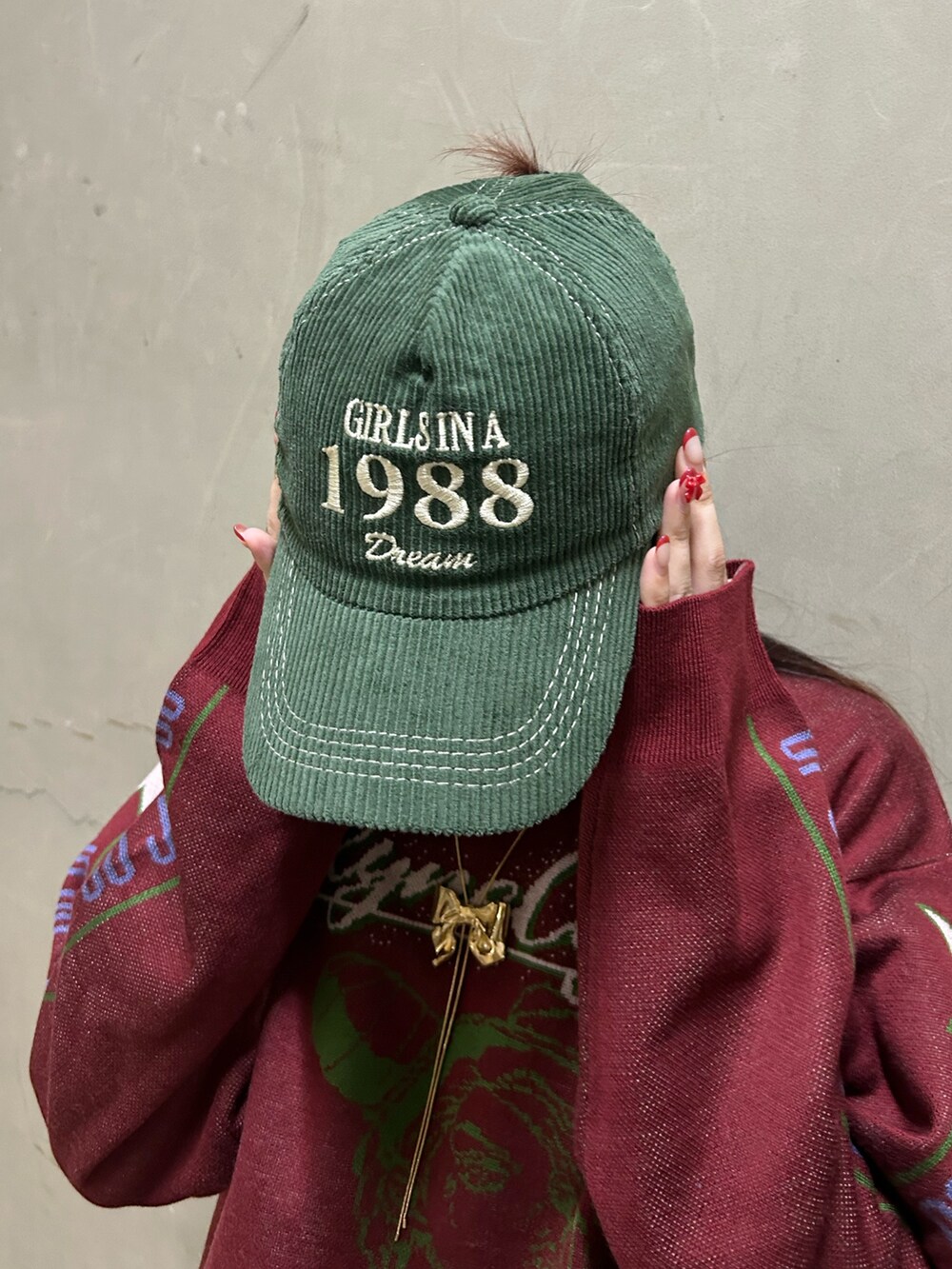 ブラック系のブーツ、レッド系のニット/セーター、グリーン系のスカートを着用したレディースの秋コーディネートの10枚目の写真