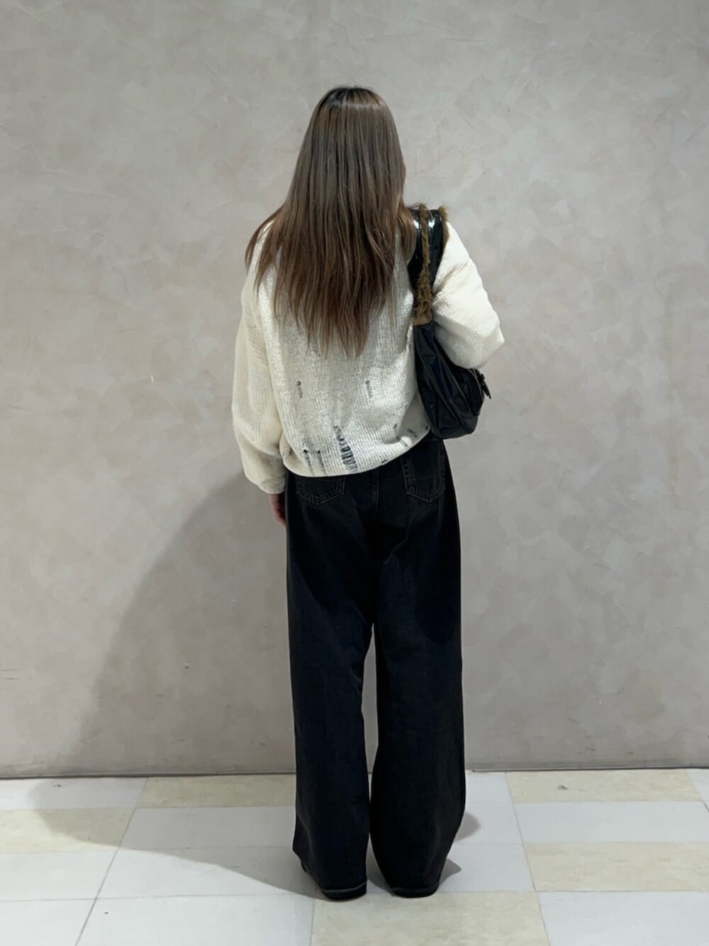 ホワイト系のシャツ/ブラウス、ホワイト系のニット/セーター、ブラック系のハンドバッグを着用したレディースの秋コーディネートの3枚目の写真