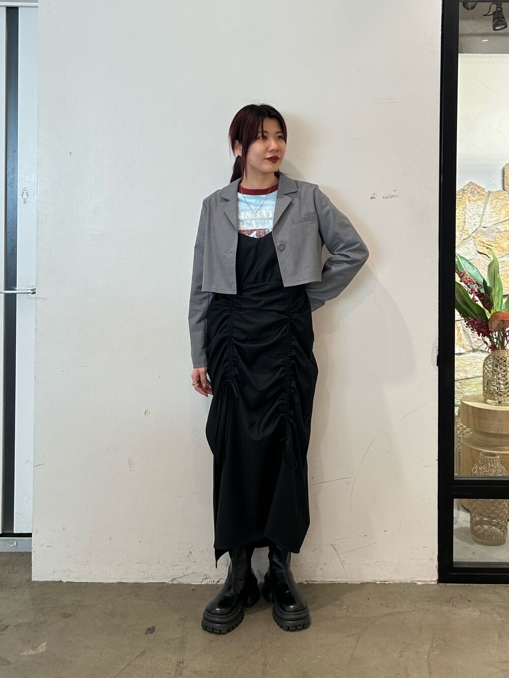 ブラック系のブーツ、ブラック系のワンピース、ブルー系のTシャツ/カットソーを着用したレディースの春コーディネートの2枚目の写真