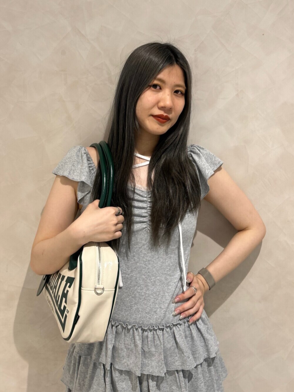 ブラック系のブーツ、グレー系のワンピース、ホワイト系のボストンバッグを着用したレディースの秋コーディネートの4枚目の写真