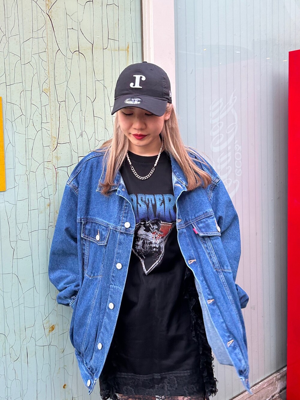 ブラック系のブーツ、ブラック系のワンピース、ブルー系のデニムジャケットを着用したレディースの春コーディネートの4枚目の写真