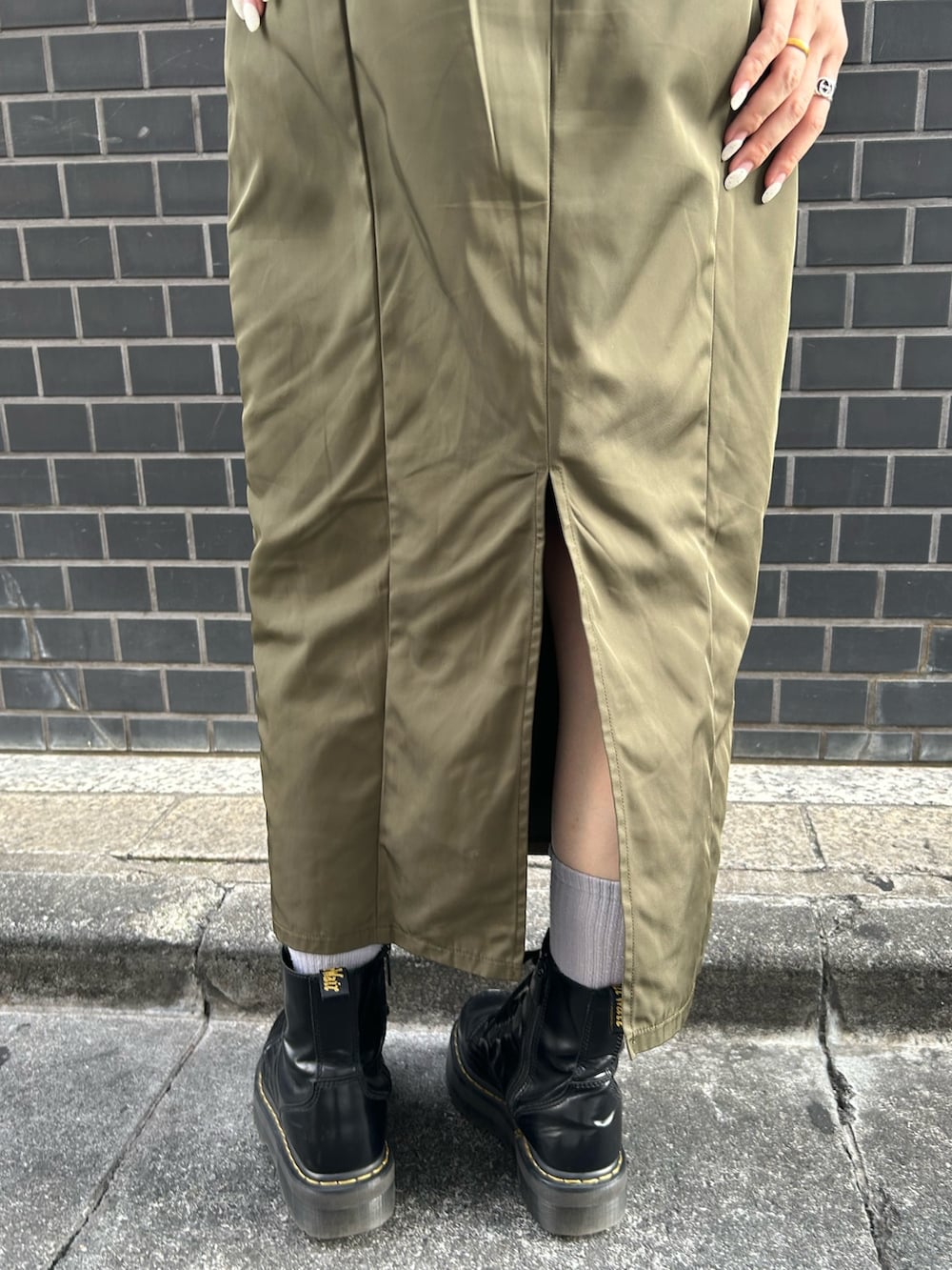 ブラック系のブーツ、グリーン系のジャンパースカート、ホワイト系のTシャツ/カットソーを着用したレディースの夏コーディネートの8枚目の写真