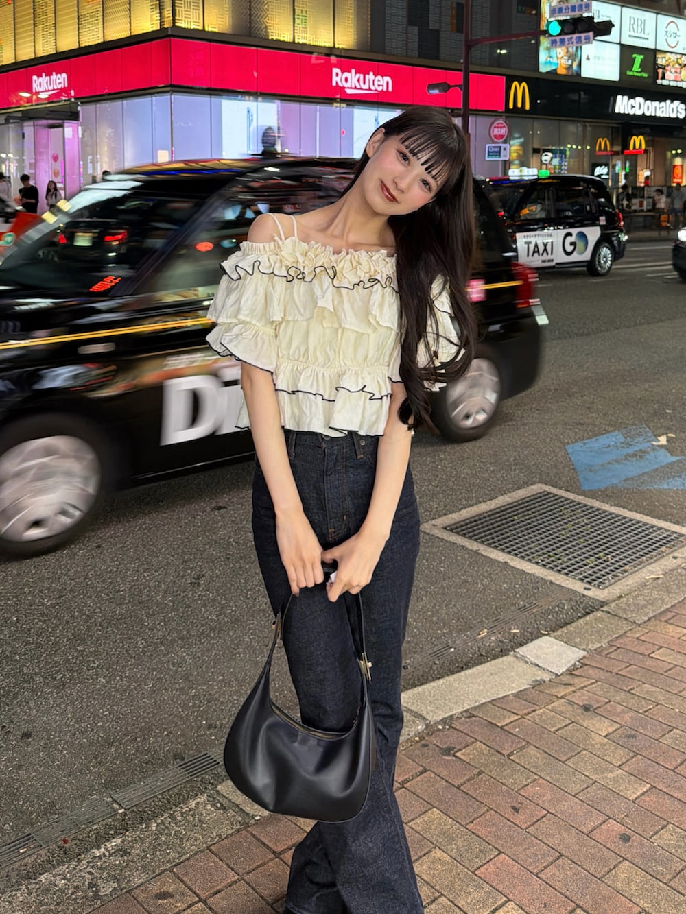 ブルー系のデニムパンツ、その他のトップス、ブラック系のハンドバッグを着用したレディースの夏コーディネートの3枚目の写真