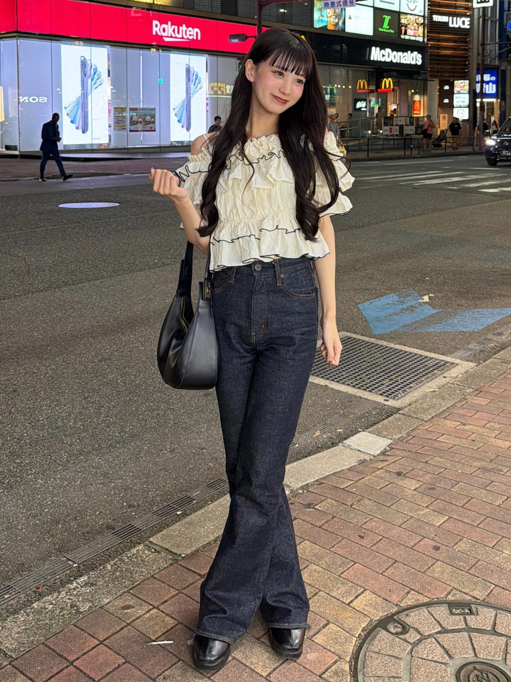 ブルー系のデニムパンツ、その他のトップス、ブラック系のハンドバッグを着用したレディースの夏コーディネートの2枚目の写真