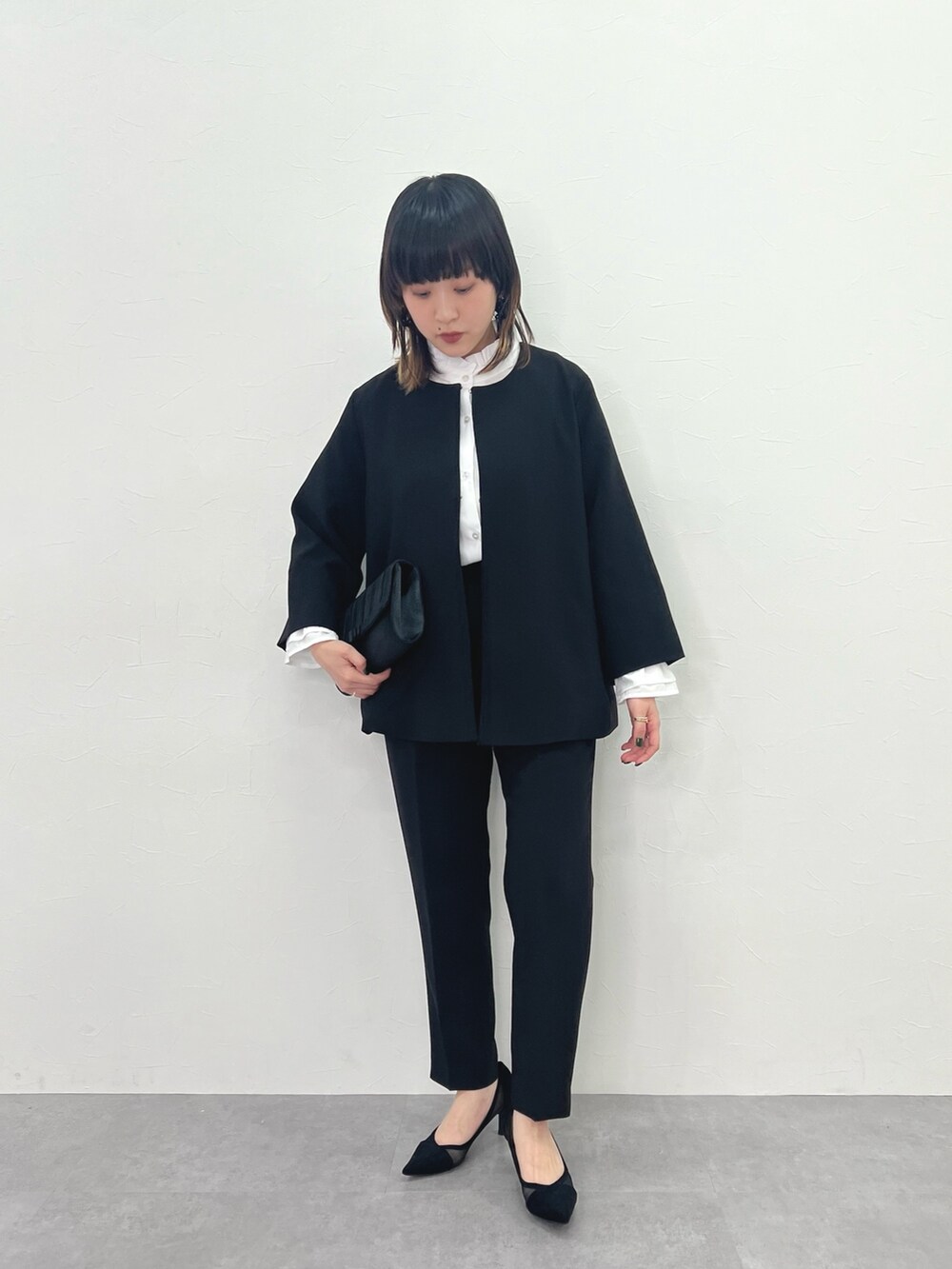 ブラック系のスーツセットを着用したレディースの冬コーディネートの3枚目の写真