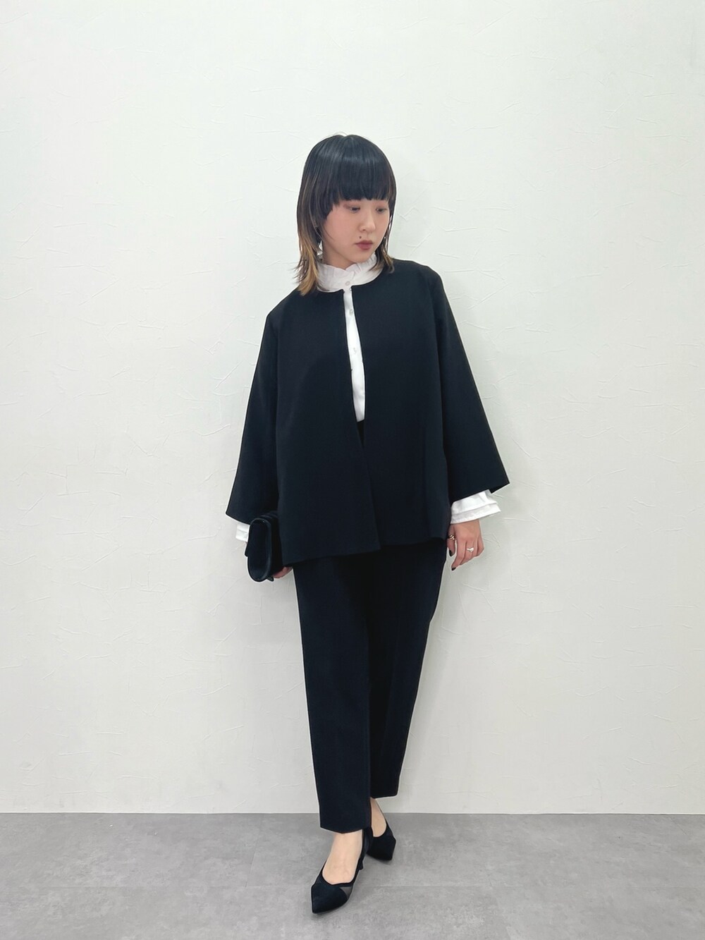 ブラック系のスーツセットを着用したレディースの冬コーディネートの2枚目の写真