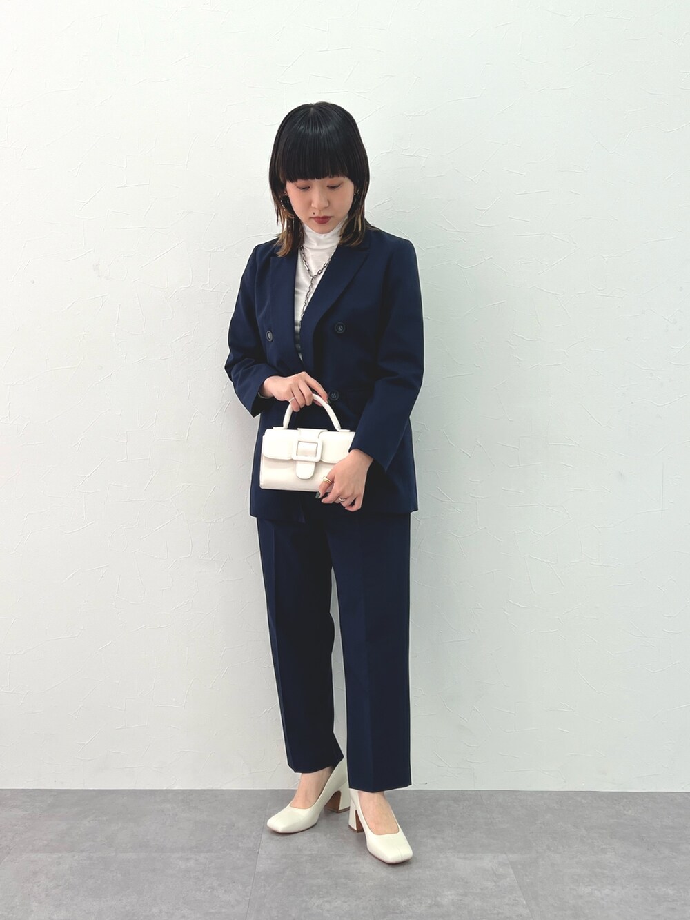 ブルー系のテーラードジャケット、ブルー系のパンツ、ホワイト系のTシャツ/カットソーを着用したレディースの冬コーディネートの2枚目の写真