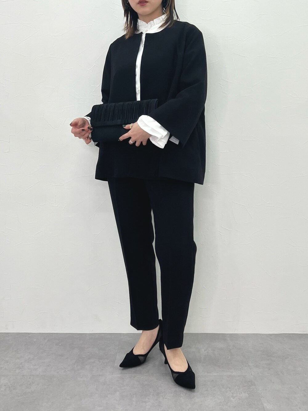 ブラック系のスーツセットを着用したレディースの冬コーディネートの4枚目の写真