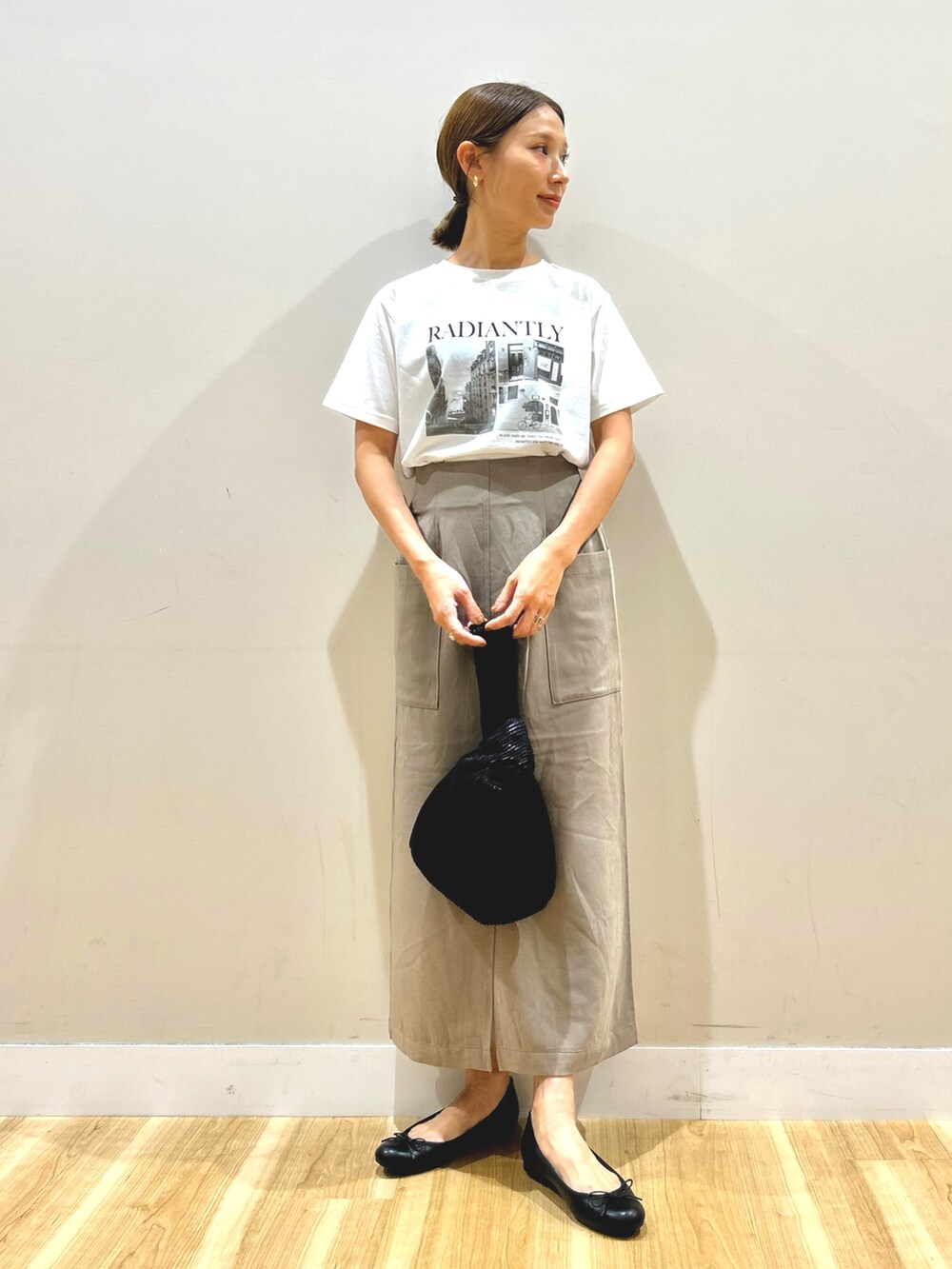 ブラック系のカーディガン/ボレロ、ホワイト系のTシャツ/カットソー、ブラウン系のスカートを着用したレディースの秋コーディネートの4枚目の写真