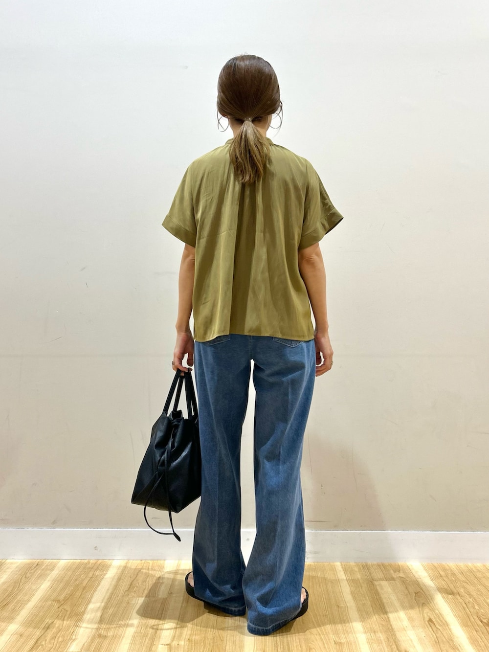 イエロー系のシャツ/ブラウス、ブルー系のデニムパンツ、ブラック系のショルダーバッグを着用したレディースの夏コーディネートの3枚目の写真