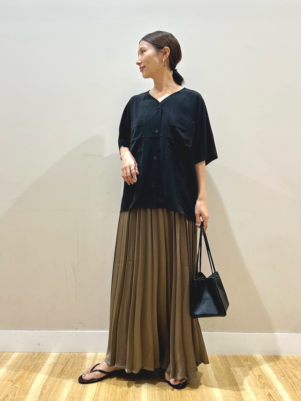 ブラック系のシャツ/ブラウス、ブラウン系のスカート、ブラック系のハンドバッグを着用したレディースの夏コーディネートの6枚目の写真