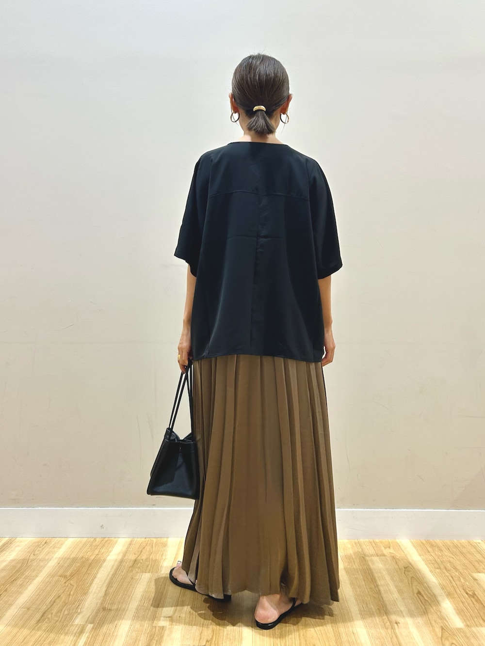 ブラック系のシャツ/ブラウス、ブラウン系のスカート、ブラック系のハンドバッグを着用したレディースの夏コーディネートの4枚目の写真