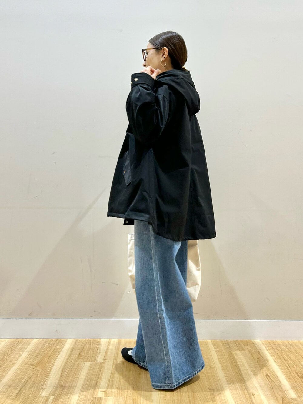 ブルー系のデニムパンツ、ベージュ系のショルダーバッグ、ピンク系のニット/セーターを着用したレディースの冬コーディネートの3枚目の写真