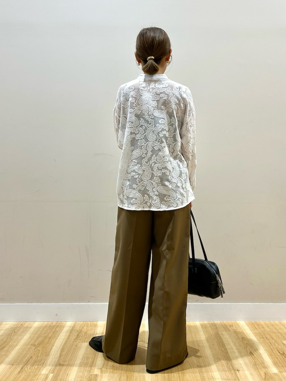 ブラウン系のその他パンツ、ブラック系のボストンバッグ、ホワイト系のシャツ/ブラウスを着用したレディースの秋コーディネートの3枚目の写真