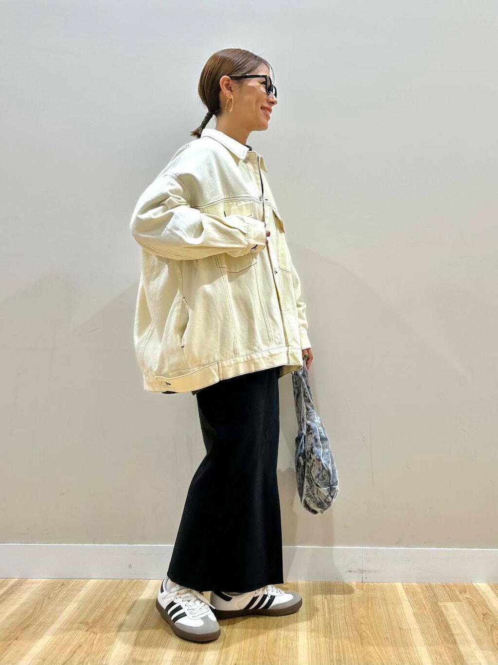 グレー系のハンドバッグ、ブラック系のニット/セーター、ブラック系のスカートを着用したレディースの冬コーディネートの3枚目の写真